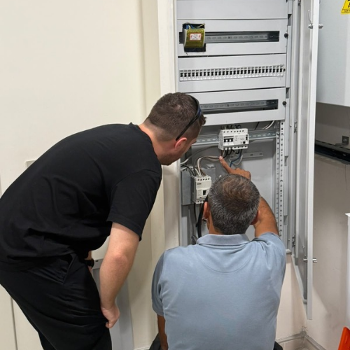 Bir elektrik panosunda birlikte çalışan ekip